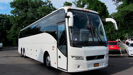 A white bus is parked in the parking lot.