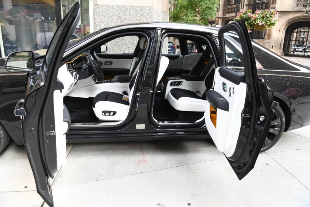 A car with open doors and seats in the back.